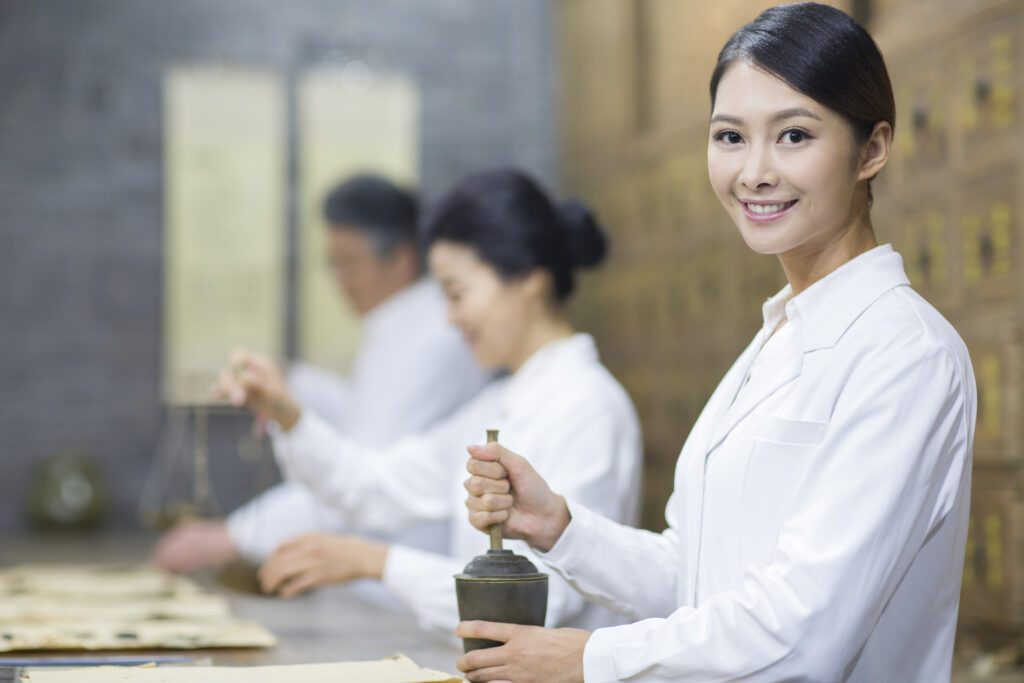 Wellness practitioner preparing holistic care at an aesthetics face & body spa inspired by Traditional Chinese Medicine principles