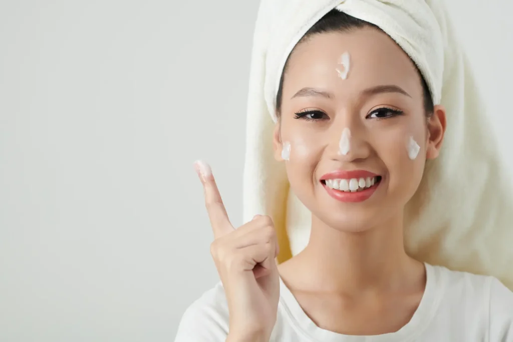 Woman applying moisturiser as part of a bojin facial treatment skincare routine