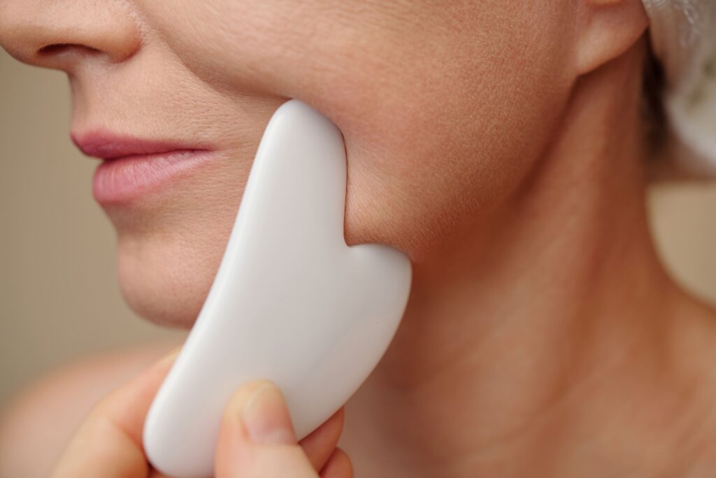 a woman using gua sha at home to add to her Bojin facial treatment in Singapore